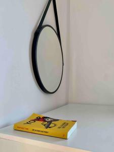 a book sitting on a table next to a mirror at Luxury spacious apartment in the heart of the city in Rhodes Town