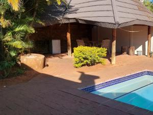 a house with a swimming pool and a pavilion at B&O's Place in Pretoria