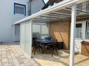 eine Terrasse mit einem Tisch und Stühlen auf einer Terrasse in der Unterkunft Hotel Meereswoge in Cuxhaven