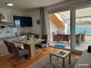 a kitchen and living room with a table and chairs at Apartments Bouvier in Pag