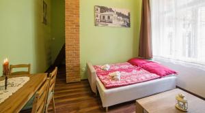 um quarto com uma cama com lençóis cor-de-rosa e uma mesa em Apartmán u Bretschneidera em Banská Štiavnica