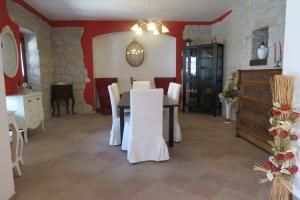 una sala da pranzo con tavolo e sedie bianche di DA LELLO - Bed & Relax a Torrecuso