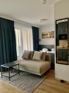 a living room with a couch and a bed at REMAR - Apartamenty Biale z widokiem na Jezioro Biale in Augustów