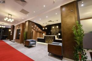 a lobby of a hotel with a red carpet at Hotel Chaker in Batna