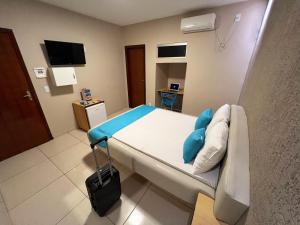 um quarto de hospital com uma cama e uma mala em Dok Brasília Hotel Unidade Águas Claras em Taguatinga