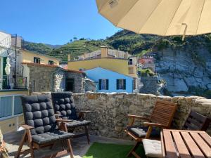 a patio with two chairs and an umbrella at La Marina Tower Apartment with private sea view terrace in Vernazza