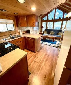 cocina con armarios de madera y sala de estar. en Oak Knoll Village, en Palomar Mountain