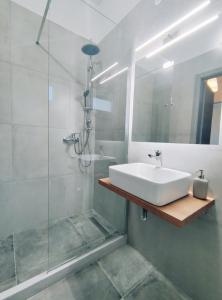 bagno con lavandino bianco e doccia di Coritos holiday apartments a Kontokali