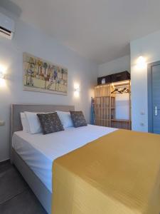 una camera da letto con un grande letto con una coperta gialla di Coritos holiday apartments a Kontokali