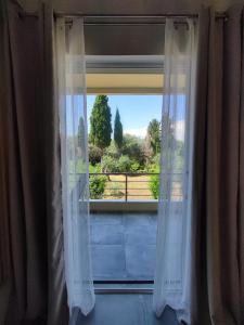 a window with white curtains looking out at a view at Coritos holiday apartments in Kontokali