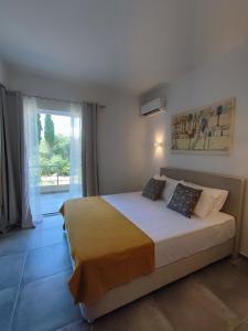 a bedroom with a bed and a large window at Coritos holiday apartments in Kontokali