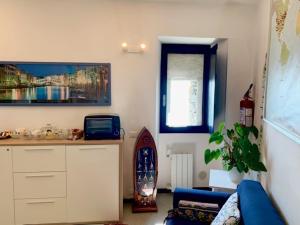 a living room with a blue couch and a surfboard at La Marina Tower Apartment with private sea view terrace in Vernazza