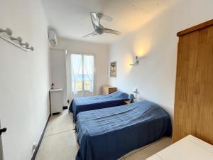 een slaapkamer met 2 bedden en een plafondventilator bij Vue mer, Mas T3 de 60m2, Nartelle - Sardinaux in Sainte-Maxime