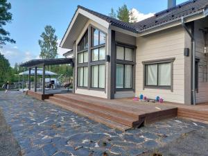 a house with a wooden deck in front of it at Villa Mustalahti in Mikkeli