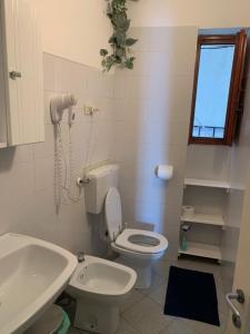 a bathroom with a white toilet and a sink at La Marina Tower Apartment with private sea view terrace in Vernazza