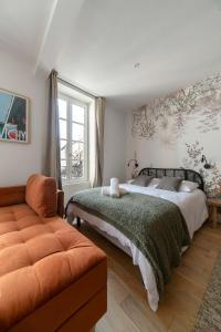 a bedroom with a bed and a couch at Residence Aristide Briand - Appartements design centre ville in Vichy