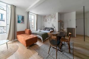 a living room with a couch a table and a bed at Residence Aristide Briand - Appartements design centre ville in Vichy