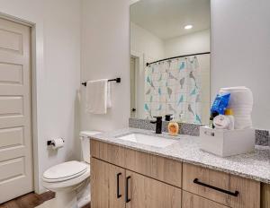 een badkamer met een toilet, een wastafel en een spiegel bij Luxury by the Pool in Lawrenceville