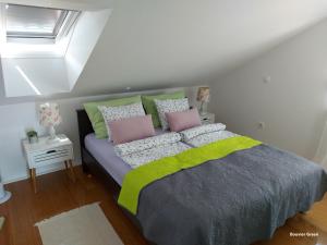 1 dormitorio con 1 cama con almohadas verdes y rosas en Apartments Bouvier, en Pag