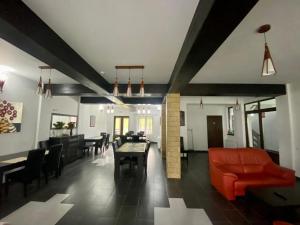 a living room with a red couch and a table at Pensiunea Cassandra in Neagra Şarului