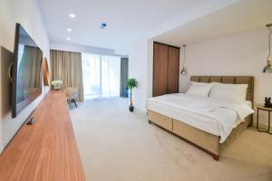 een grote slaapkamer met een groot bed en een bureau bij Luxury Hotel Riva - Budva in Budva