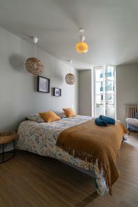 a bedroom with a bed and two pendant lights at Residence Aristide Briand - Appartements design centre ville in Vichy