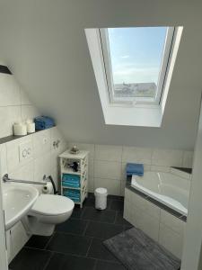 La salle de bains est pourvue de toilettes, d'un lavabo et d'une baignoire. dans l'établissement Ferienwohnung Blumenfeld, à Gengenbach