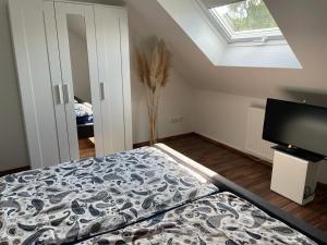 a bedroom with a bed and a window and a television at Ferienwohnung Blumenfeld in Gengenbach