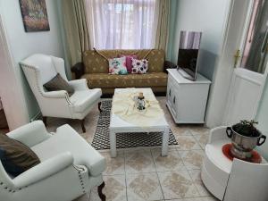 uma sala de estar com um sofá e cadeiras e uma televisão em Two Bedroom Flat in the Garden at the Bosphorus em Istambul