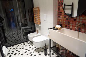 ein Badezimmer mit einem WC, einem Waschbecken und einem Spiegel in der Unterkunft Boutique suite Rome in Rom