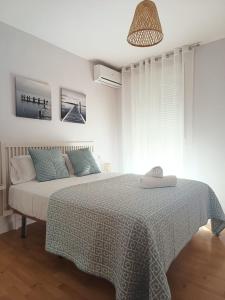 a white bedroom with a bed with a green blanket at PISO VISTA BELLA in Monachil