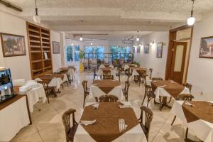 un restaurant avec des tables et des chaises dans une salle dans l'établissement Garni Hotel Milica, à Herceg-Novi
