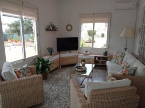 Una sala de estar con sofás y un televisor de pantalla plana. en VILLA RUSTICA JAVEA, en Jávea