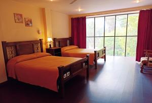 a hotel room with two beds and a large window at Hotel Maison Fiori Prado in Cochabamba