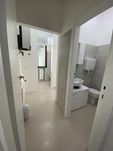 bagno bianco con 2 servizi igienici e lavandino di Ampio appartamento in posizione strategica a Rimini