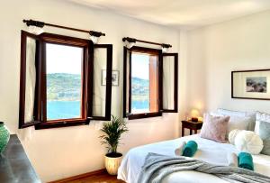 a bedroom with windows and a white bed with blue pillows at Seaview Grand - MAGIC Gundogan in Bodrum City