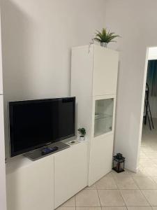 un centro di intrattenimento bianco con TV a schermo piatto di Ampio appartamento in posizione strategica a Rimini