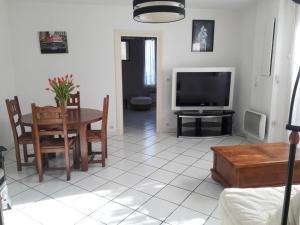 a living room with a table and a television at Les Mouflets in Fouras