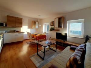 a living room with a couch and a table and a kitchen at ForRest Apartment in Portorož