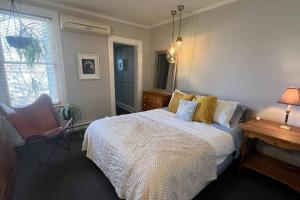 a bedroom with a bed and a chair and a window at Maison Quartier du Musée in Gatineau