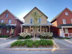 a house with a tree in the middle of a street at Maison Quartier du Musée in Gatineau