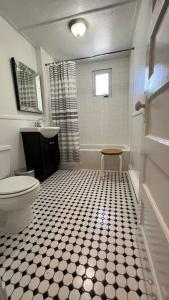 a bathroom with a toilet and a black and white tiled floor at Maison Quartier du Musée in Gatineau +27 photos