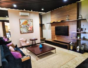 a living room with a couch and a tv at GoldMen Business Sorriso in Sorriso