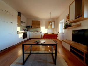 a living room with a table and a kitchen at ForRest Apartment in Portorož +18 photos