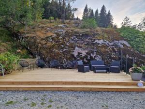 een houten terras met stoelen en stoelen op de top van een heuvel bij Kvamsdal Pensjonat 2 in Eidfjord