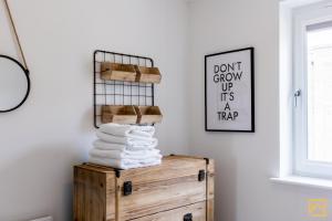 ミルトン・キーンズにあるOutstanding 5 Bedroom Townhouse, Canal Views By Valore Property Servicesの部屋の木箱の上に積み重ねられたタオル +90枚の写真