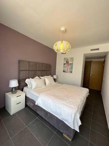 Un dormitorio con una cama grande y una lámpara de araña. en luxury apartment in City Center Hilton en Tánger
