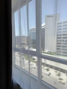 a window with a view of a city from a building at luxury apartment in City Center Hilton in Tangier