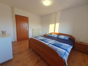 a bedroom with a bed with a blue blanket on it at ForRest Apartment in Portorož