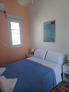 a bedroom with a blue bed and a window at Orizodas in Leipsoi